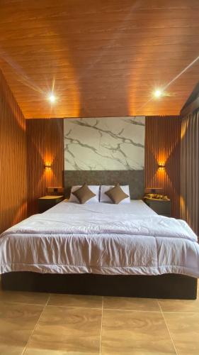 a bedroom with a large white bed with two lamps at Lombok Grace Bungalows in Tetebatu