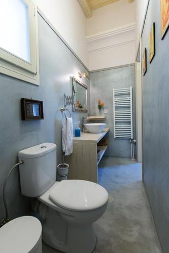 a bathroom with a white toilet and two sinks at Titania il giardino segreto di prospero in Ýpsos