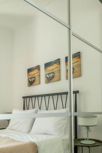 a bedroom with a white bed and three pictures on the wall at casa in piazza in Pylos
