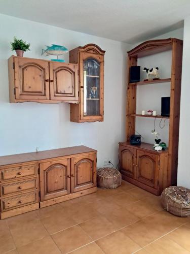 a kitchen with wooden cabinets and a window at Apartamento MILA centro in Comillas