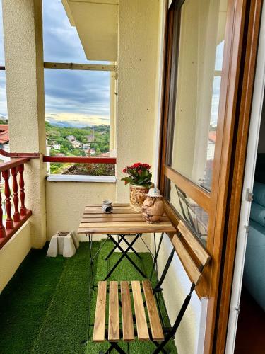 a balcony with a wooden table and a bench at Apartamento MILA centro in Comillas