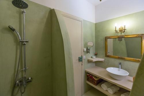 a bathroom with a sink and a shower with a mirror at Titania il giardino segreto di prospero in Ýpsos