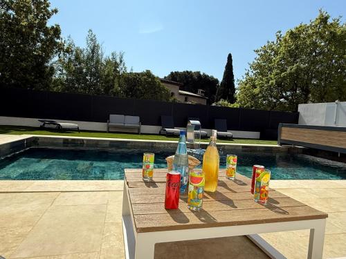 - une table avec des boissons à côté de la piscine dans l'établissement Villa 200m2 -plages - piscine chauffée, à Fréjus