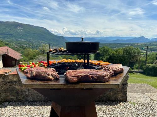 - un grill avec de la viande et un pot en haut dans l'établissement Le Prieuré, à Belmont