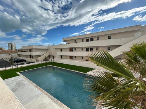 une piscine devant un immeuble dans l'établissement Naïa Coud, à Sérignan