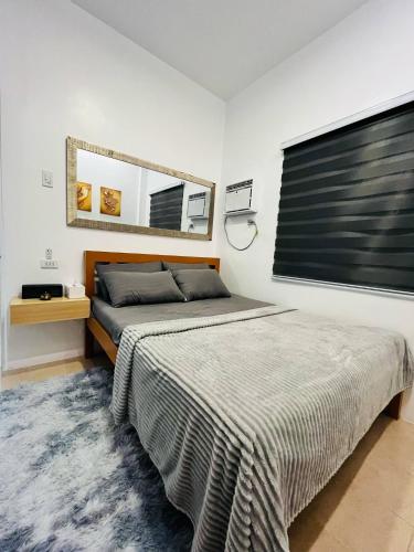a bedroom with a bed and a mirror on the wall at Casa Esperanza 1376 in Dauis
