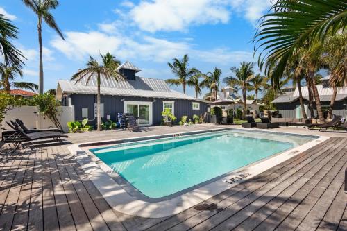 a swimming pool in front of a house with palm trees at Villa #3 Seahorse in Holmes Beach