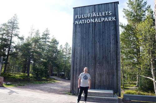 a man standing in front of a sign at a park at 16 - Fulufjellets nasjonalparker - snø - alpint - langrenn - snøscooter in Ljørdal
