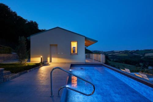 a swimming pool in front of a house at Le Cune, Apt Cipressino - AC, Pool & Jacuzzi in Palazzo