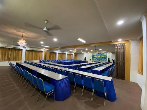 a lecture hall with blue tables and chairs at Satya Graha Hotel in Timuran