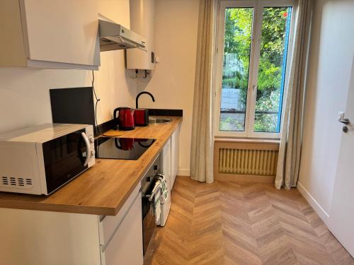 a kitchen with a microwave and a stove top oven at Le Cocon de Bondy in Bondy