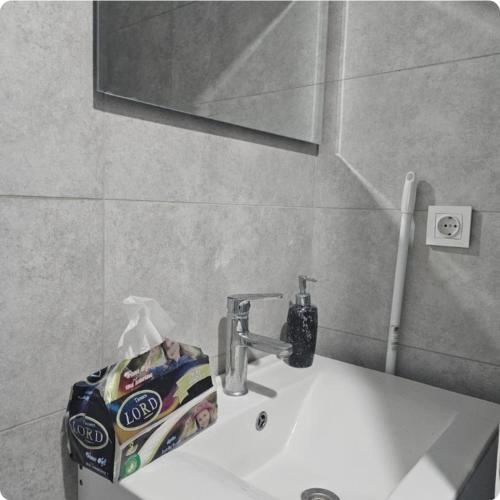 un lavandino in bagno con un tubo di dentifricio sopra di French village two a Duhok