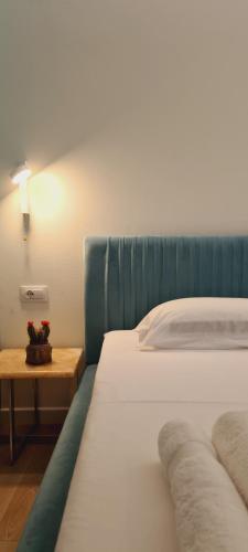 a bedroom with a bed and a night stand with a table at TIS, Green Coast in Palasë