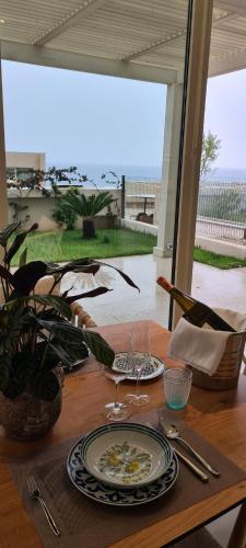 a wooden table with plates and wine glasses on it at TIS, Green Coast in Palasë