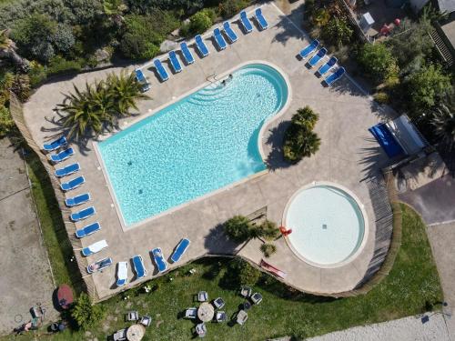 une vue aérienne d'une piscine avec des chaises longues et des parasols dans l'établissement Camping Baie de Saint Pol, à Saint-Pol-de-Léon
