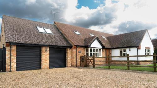 a detached detached house with a garage at Superb 4BD Stay in Wyton and Houghton Village in Wyton