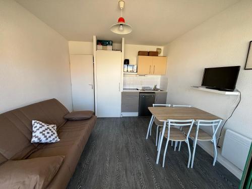 un salon avec un canapé et une table et une cuisine dans l'établissement Cap Océan, à Mimizan