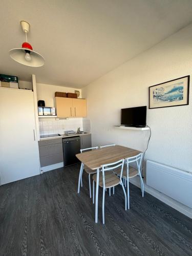 une petite pièce avec une table et une cuisine dans l'établissement Cap Océan, à Mimizan