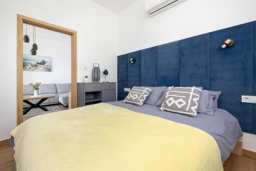 ein Schlafzimmer mit einem großen Bett und einer blauen Wand in der Unterkunft Apartamenty Piaskowa 11 in Gąski