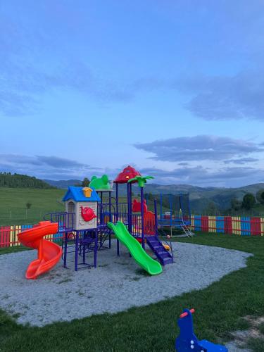 a playground with colorful play equipment in the sand at Hotel Măgura Jina in Jina