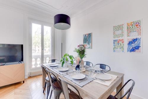 une salle à manger avec une table avec des chaises et une télévision dans l'établissement Appartement spacieux à deux pas de Notre-Dame, à Paris