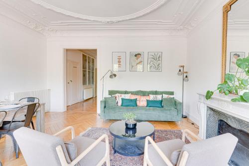 un salon avec un canapé vert et une table dans l'établissement Appartement spacieux à deux pas de Notre-Dame, à Paris