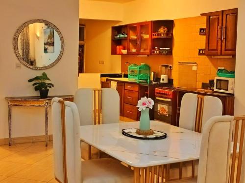 a kitchen with a table and chairs and a kitchen with yellow walls at Shanzu Oceanline Apartments La Mera in Mombasa