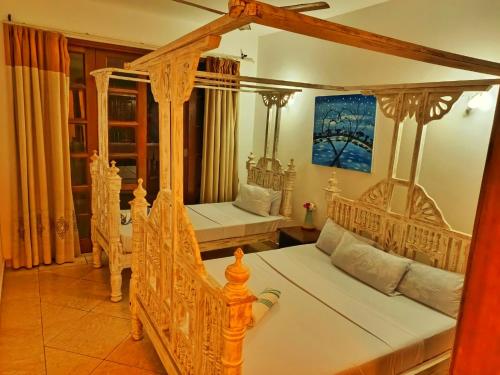 a bedroom with two canopy beds with white sheets at Shanzu Oceanline Apartments La Mera in Mombasa