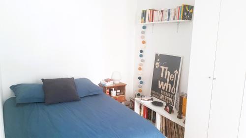 - une chambre avec un lit bleu et une étagère dans l'établissement 2 pièces à Montmatre, à Paris