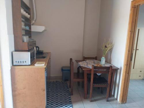 a small kitchen with a table and a microwave at Ilios Kalamaki in Kalamaki Heraklion