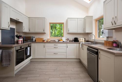 a large white kitchen with white cabinets and appliances at Vesta View in Hexham
