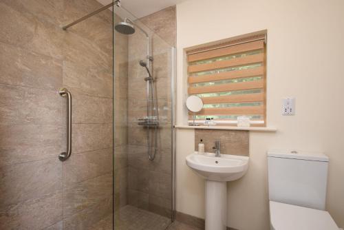 a bathroom with a shower and a toilet and a sink at Vesta View in Hexham
