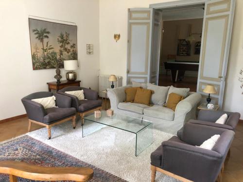 a living room with a couch and chairs and a table at La Tanière, maison familiale avec piscine, 13 couchages in Moulin-Neuf