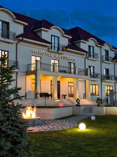a building with a fire in front of it at Hotel Măgura Jina in Jina