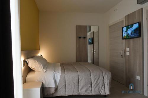 a bedroom with a bed with a television on the wall at Al Bacino Rooms And Breakfast in Porto Viro