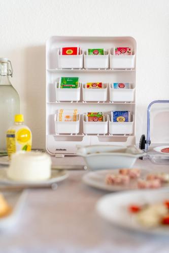 an open refrigerator with plates of food on a table at Pension Latemar in Caldaro