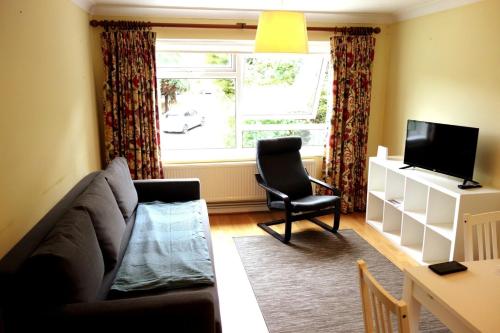 a living room with a couch and a tv at NEW Cosy 2 Bedroom Flat - Englefield Green in Englefield Green