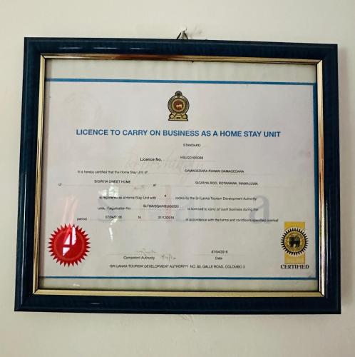 a certificate in a framed picture of a home stay unit at Sigiriya Sweet Home Guest House in Inamaluwa