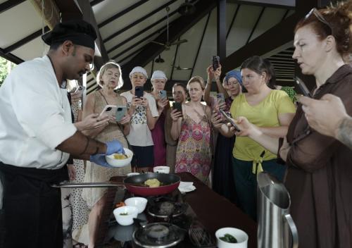 a man is serving food to a group of people at Jeevess Retreat Wayanad in Wayanad