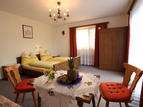 a living room with a table and a bed at Haus Jochblick Familie Loinger in Itter