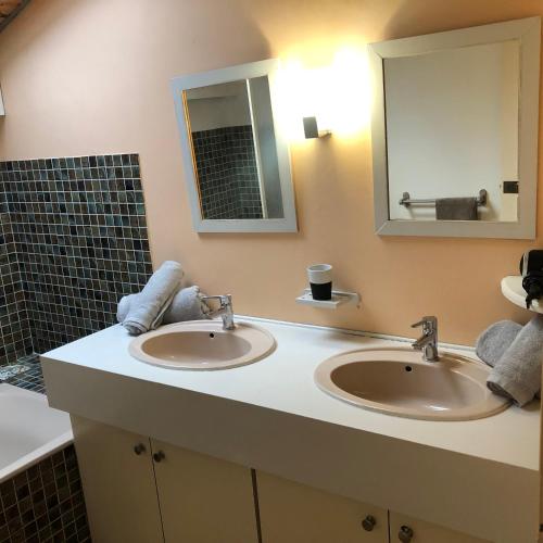 une salle de bain avec deux lavabos et un miroir dans l'établissement Villa Prune 200m 5 chambres avec piscine et garage, à Aix-les-Bains