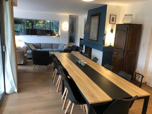 a living room with a large wooden table and chairs at Villa Prune 200m 5 chambres avec piscine et garage in Aix-les-Bains