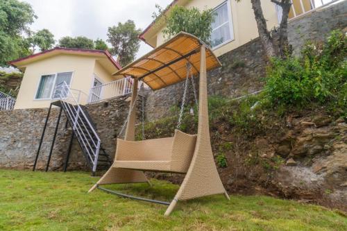 a swing set in a yard in front of a house at Ila by Aaryam, Kanatal in Chamba