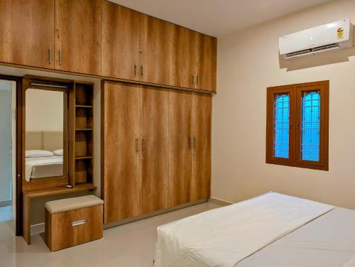 a bedroom with wooden cabinets and a bed and a window at Yellowra Farmstay Tiruvannamalai in Tiruvannāmalai