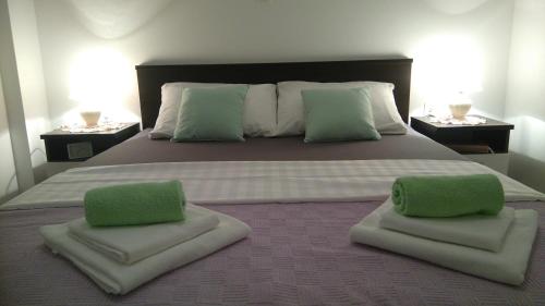 a bedroom with a bed with two green pillows at Apartments Lipić in Posedarje
