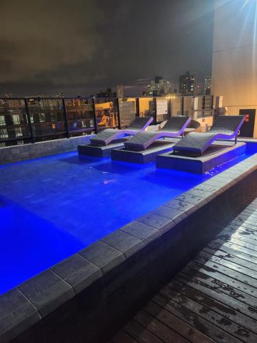 a pool on the roof of a building at night at Loft aconchegante à Beira-Mar in João Pessoa