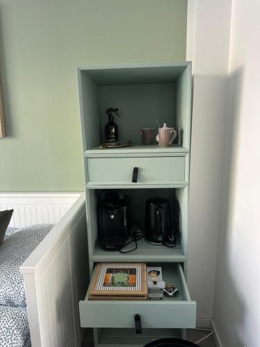 une étagère verte avec une cafetière dessus dans l'établissement Chambre salle de bain aéroport CDG Parc des expositions Envoyez moi un message avant de faire la réservation, à Aulnay-sous-Bois