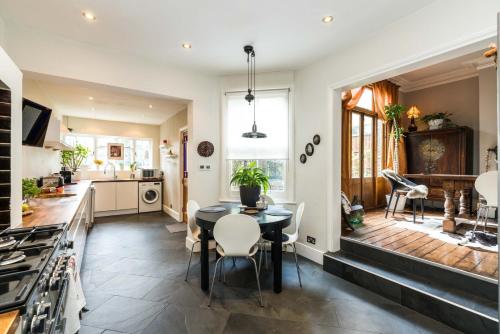 a kitchen and dining room with a table and chairs at Beautiful 3BD Home Forest Hill South London in London