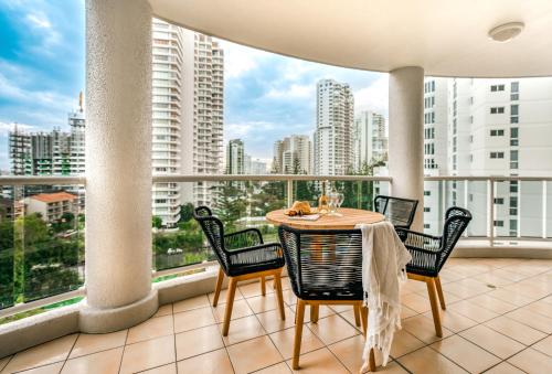 a table and chairs on a balcony with a view of a city at Xanadu Resort in Gold Coast