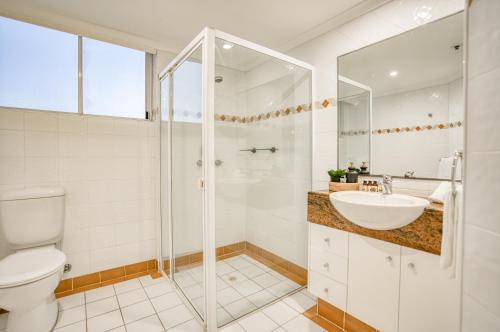 a bathroom with a shower and a sink and a toilet at Xanadu Resort in Gold Coast
